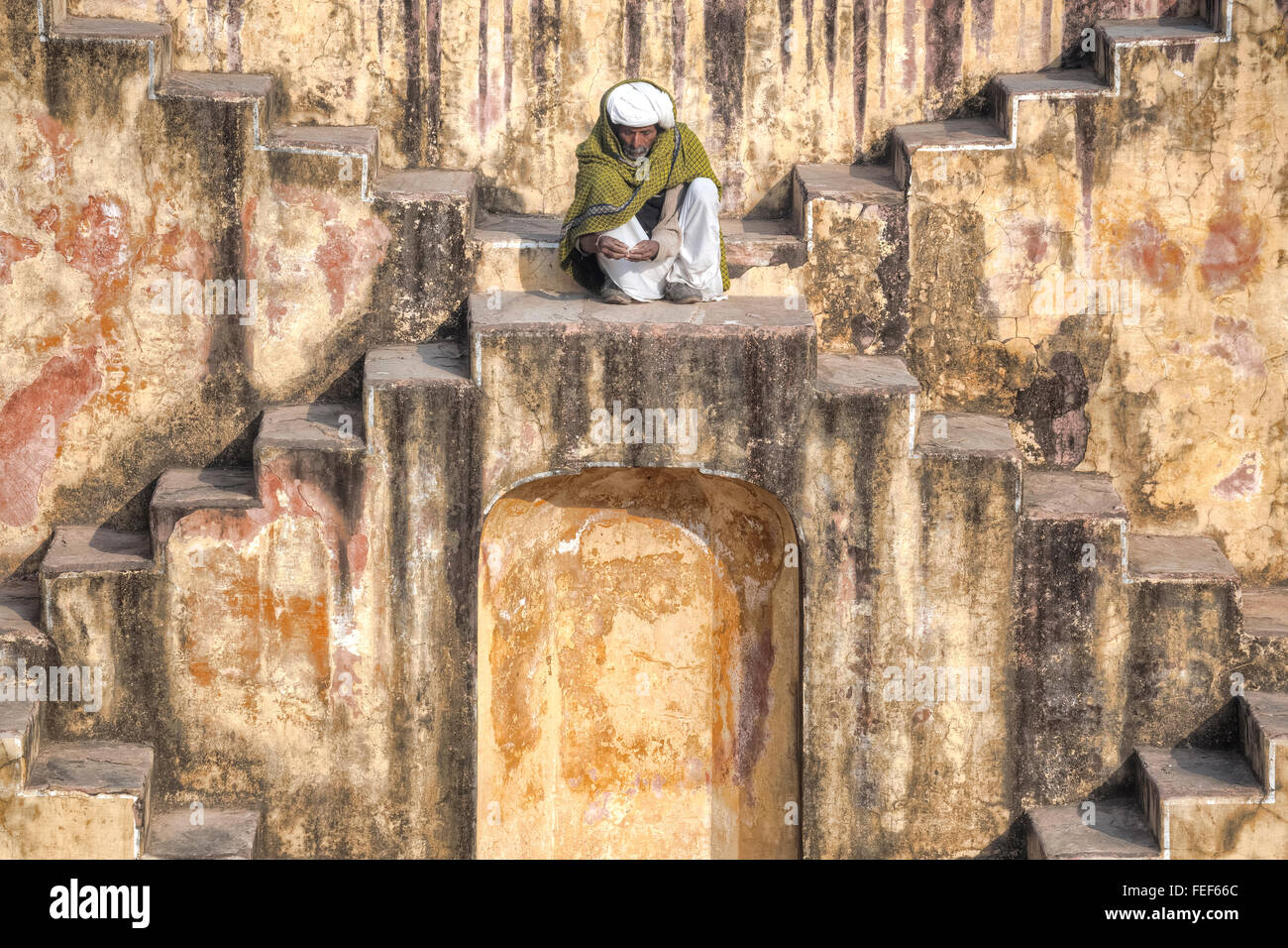 Un uomo seduto in un stepwell a Jaipur, Rajasthan, India, Asia del Sud Foto Stock