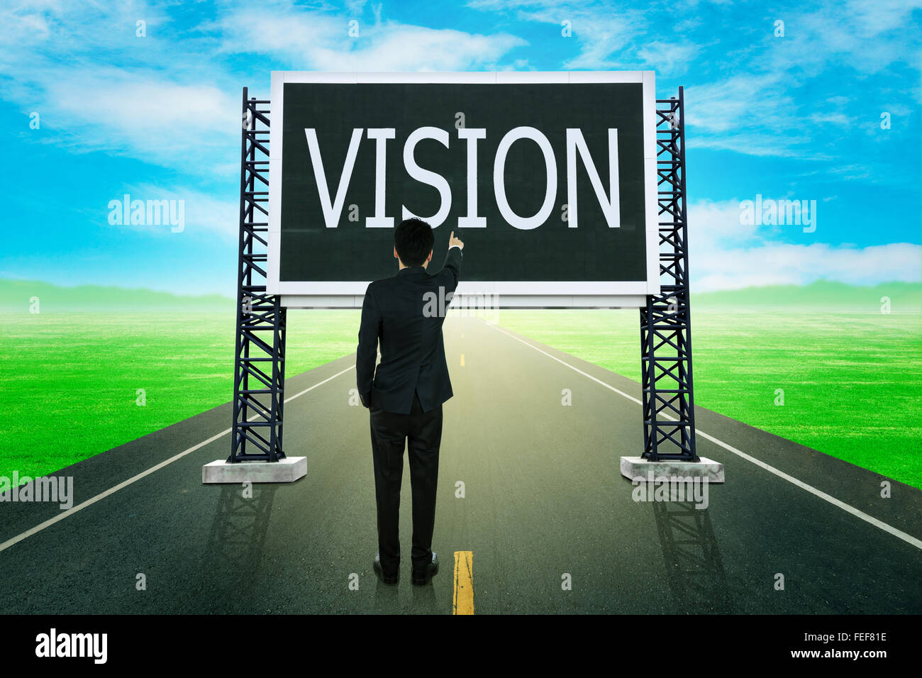 Imprenditore permanente sulla strada e dispositivo di puntamento con grande segno della visione (concetto aziendale) Foto Stock