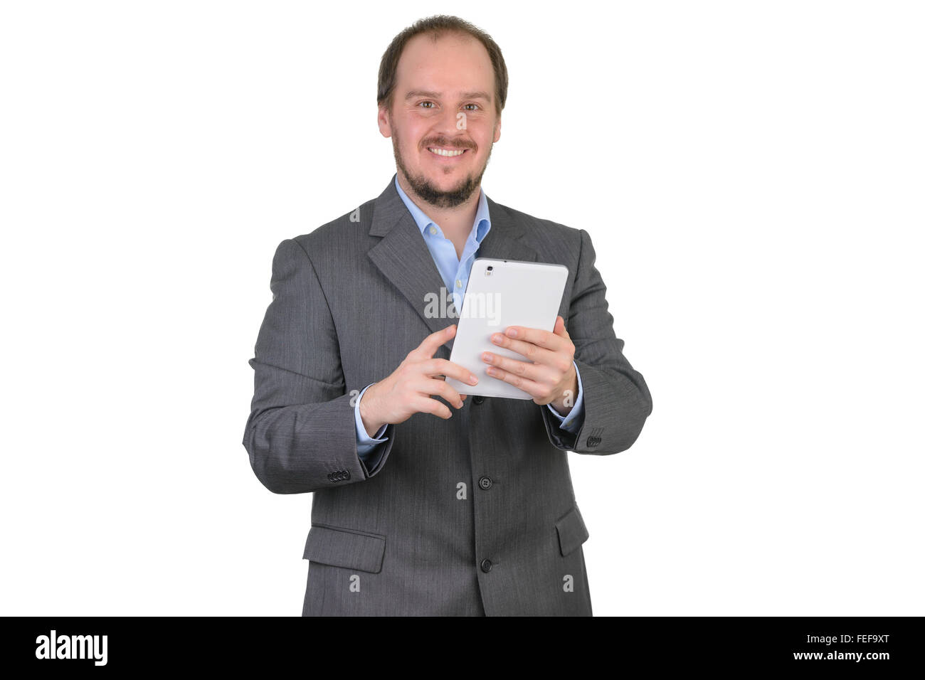 Uomo in grigio scuro suit sorridente azienda computer tablet Foto Stock