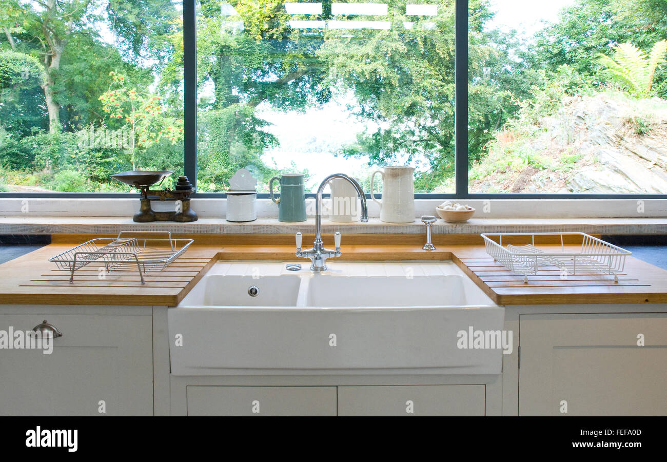 Nuova cucina bianca, ravvicinata di un lavello da cucina con la vista al di fuori della finestra. Foto Stock