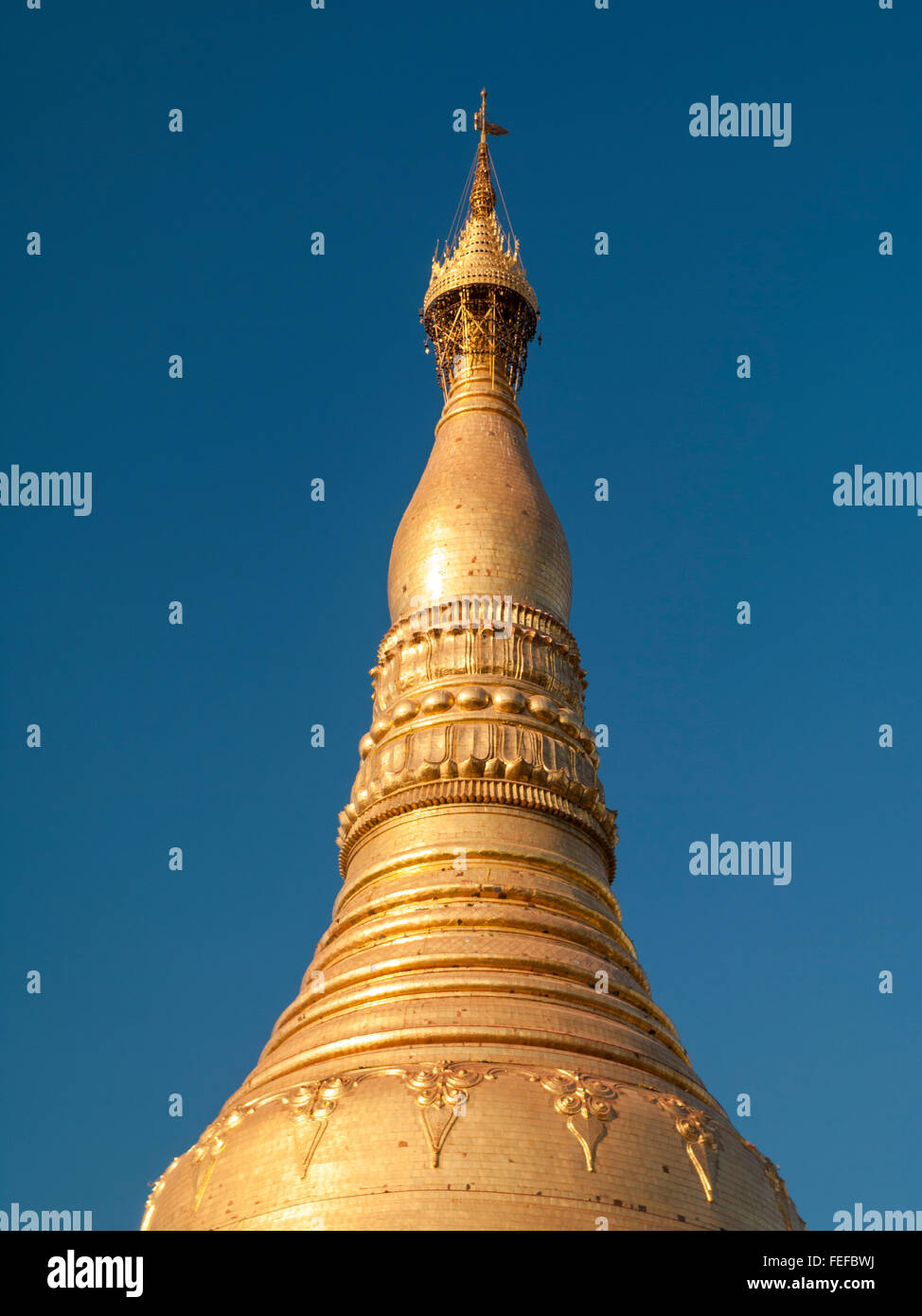Parte superiore della stupa dorato di Shwedagon Zedi Daw Pagoda e la sua Hti ornamentali, o corona ombrello ornamento. Yangon, Myanmar. Foto Stock