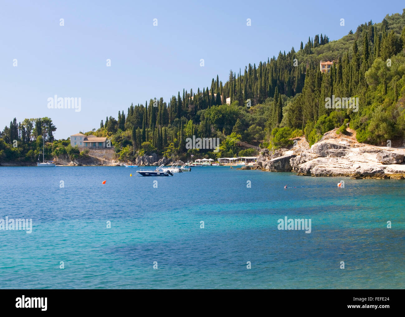 Kalami, Corfu, Isole Ionie, Grecia. Vista su tutta l'acqua turchese al Cypress-pendenze coperte sopra Agni Bay. Foto Stock