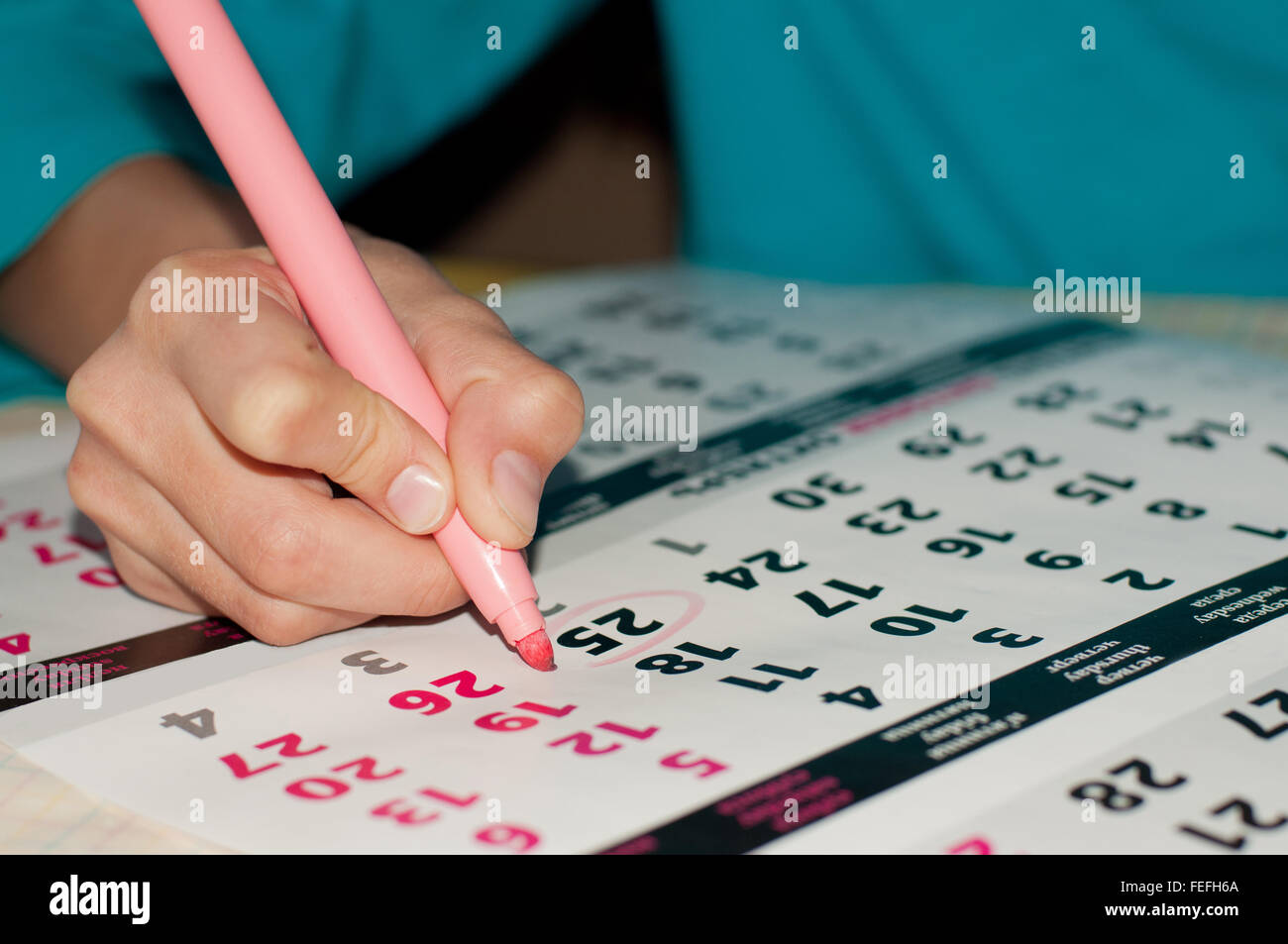 Close-up foto del calendario con un dato cerchiato da kid la mano con un marcatore di rosa, il concetto di gestione del tempo di lavoro Foto Stock