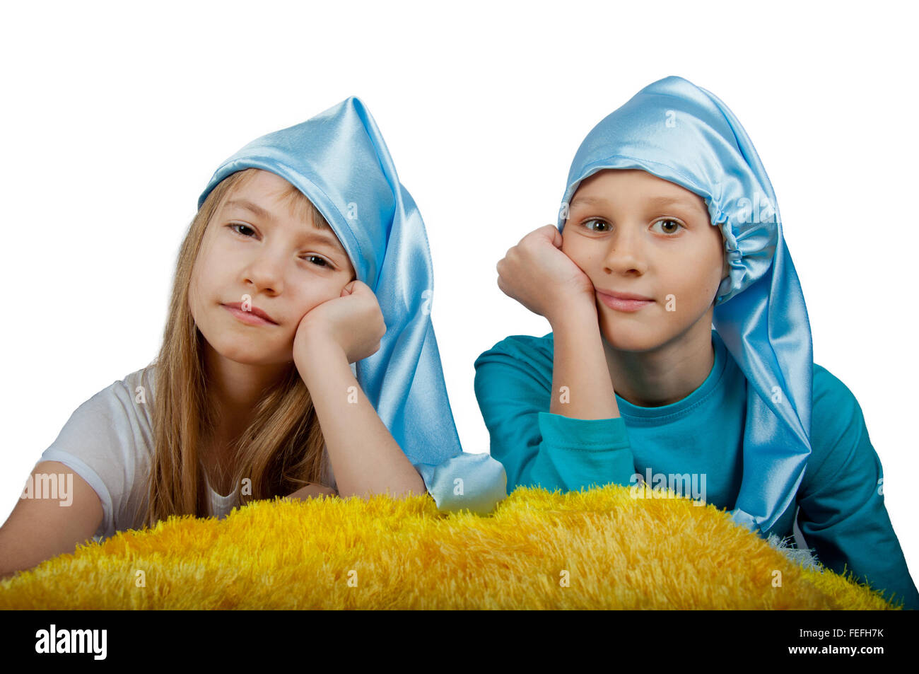 Carino un ragazzo e una ragazza in pigiama e blu cappelli di pelo isolato su bianco Foto Stock
