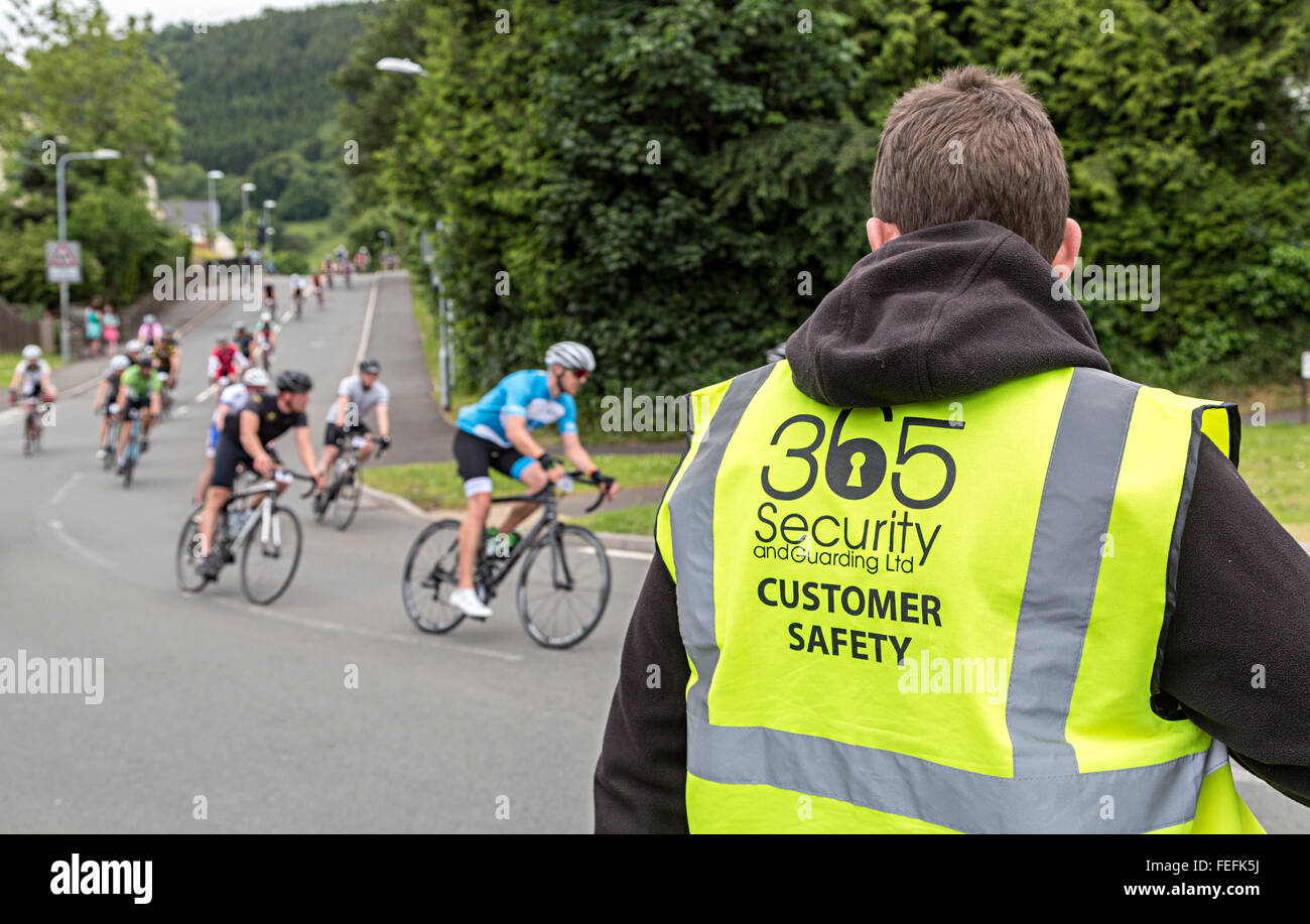 Velothon cycle race maresciallo con giubbotto di sicurezza, Llanfoist, Wales, Regno Unito Foto Stock