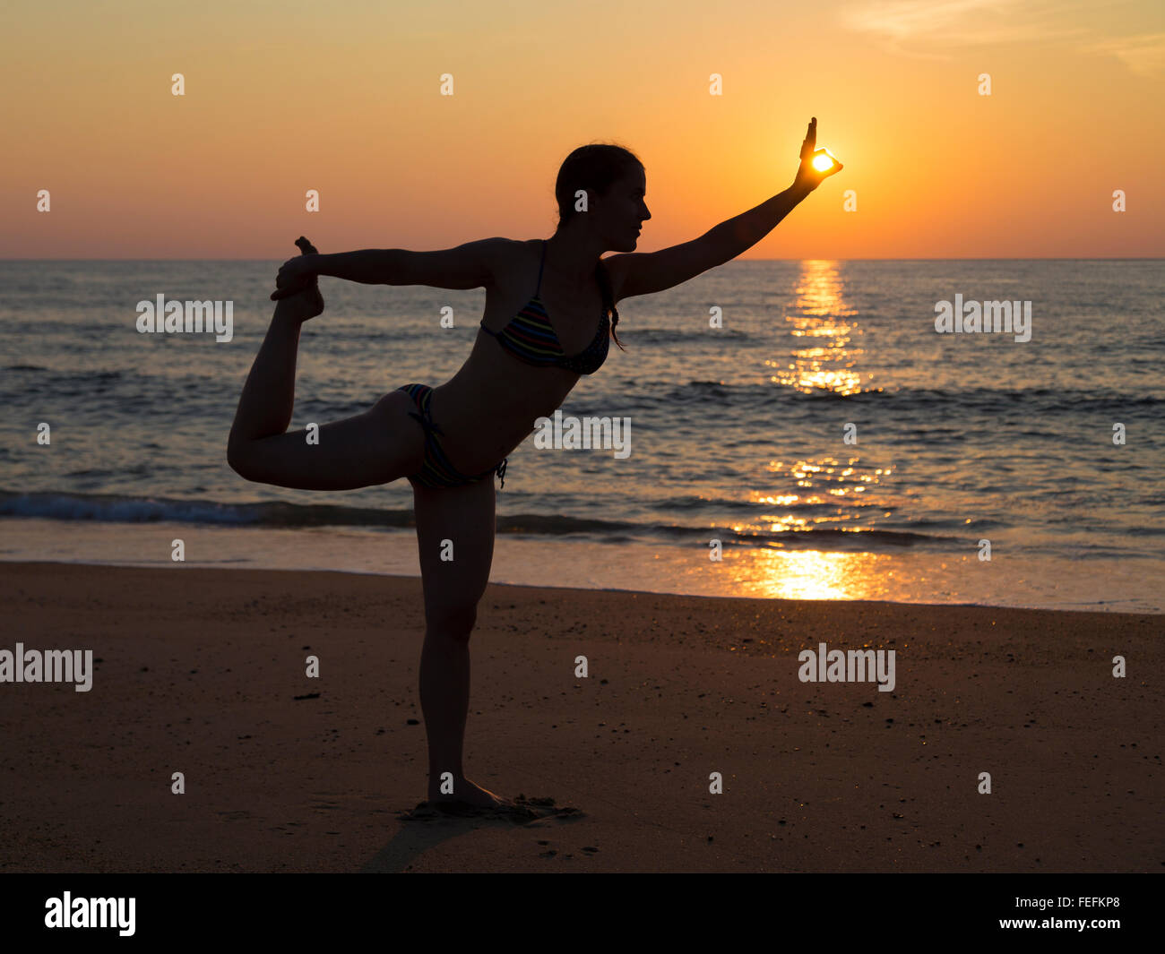 Yoga in spiaggia al tramonto Foto Stock