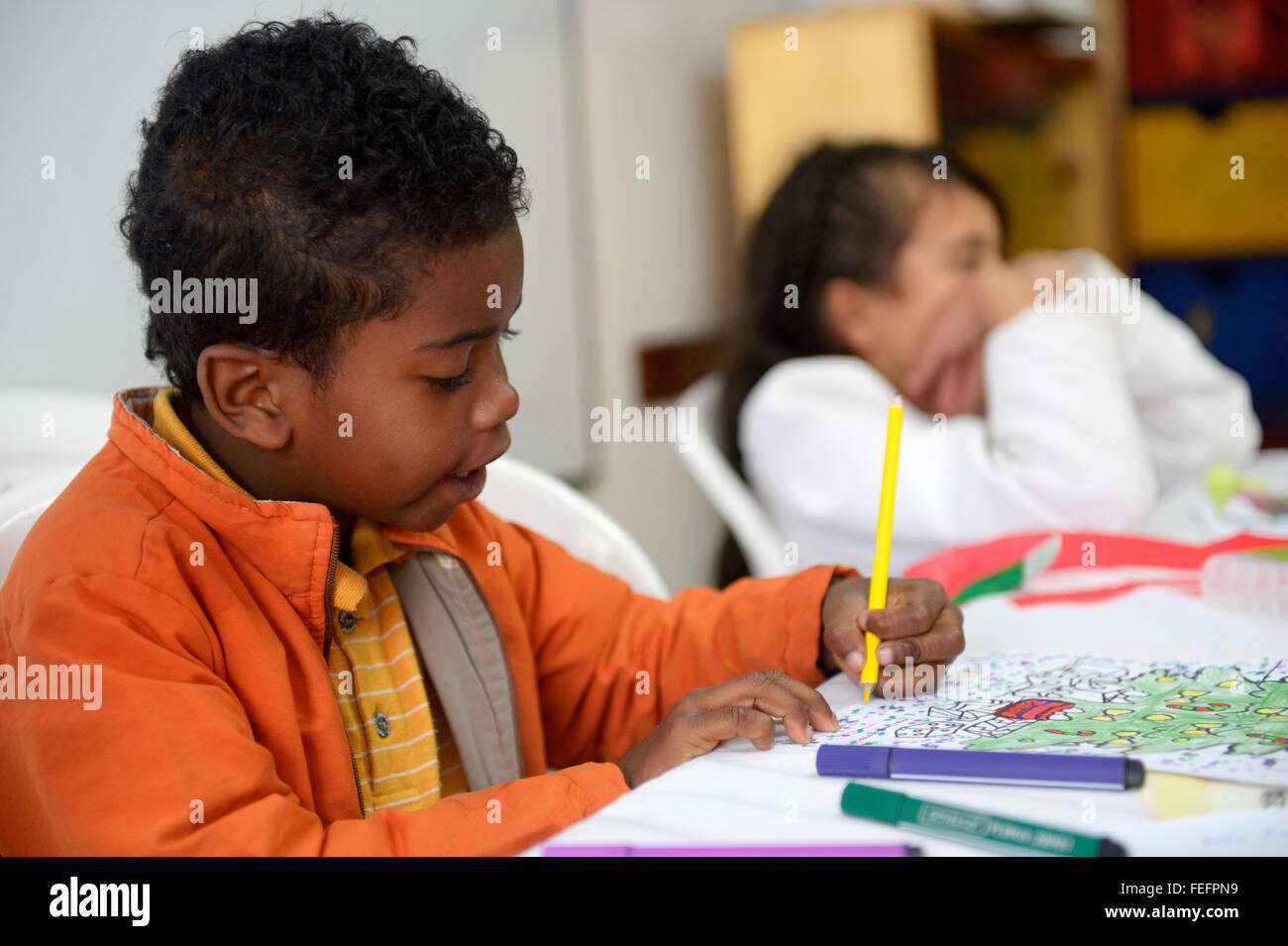 Il ragazzo, 6 anni, la colorazione in, progetto sociale Cresciendo Unidos, Javier Villa, Bogotà, Colombia Foto Stock