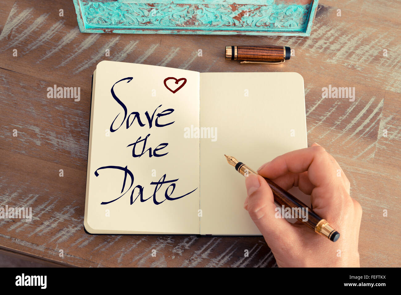 Effetto retrò e tonico immagine di una donna la scrittura a mano una nota con una penna stilografica su un notebook. Foto Stock