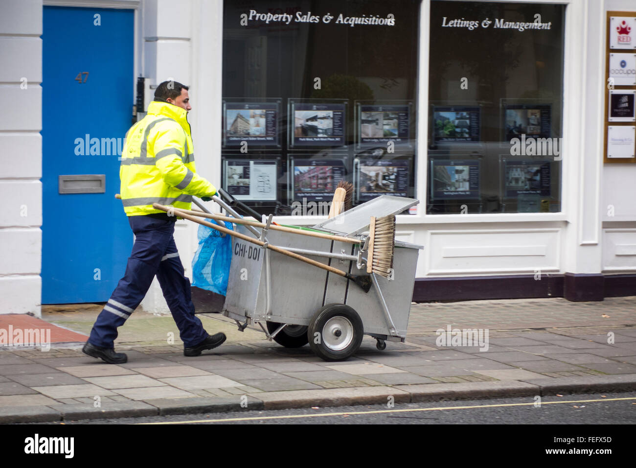 Pulitore di strada camminando su un marciapiede in Londra, Regno Unito Foto Stock