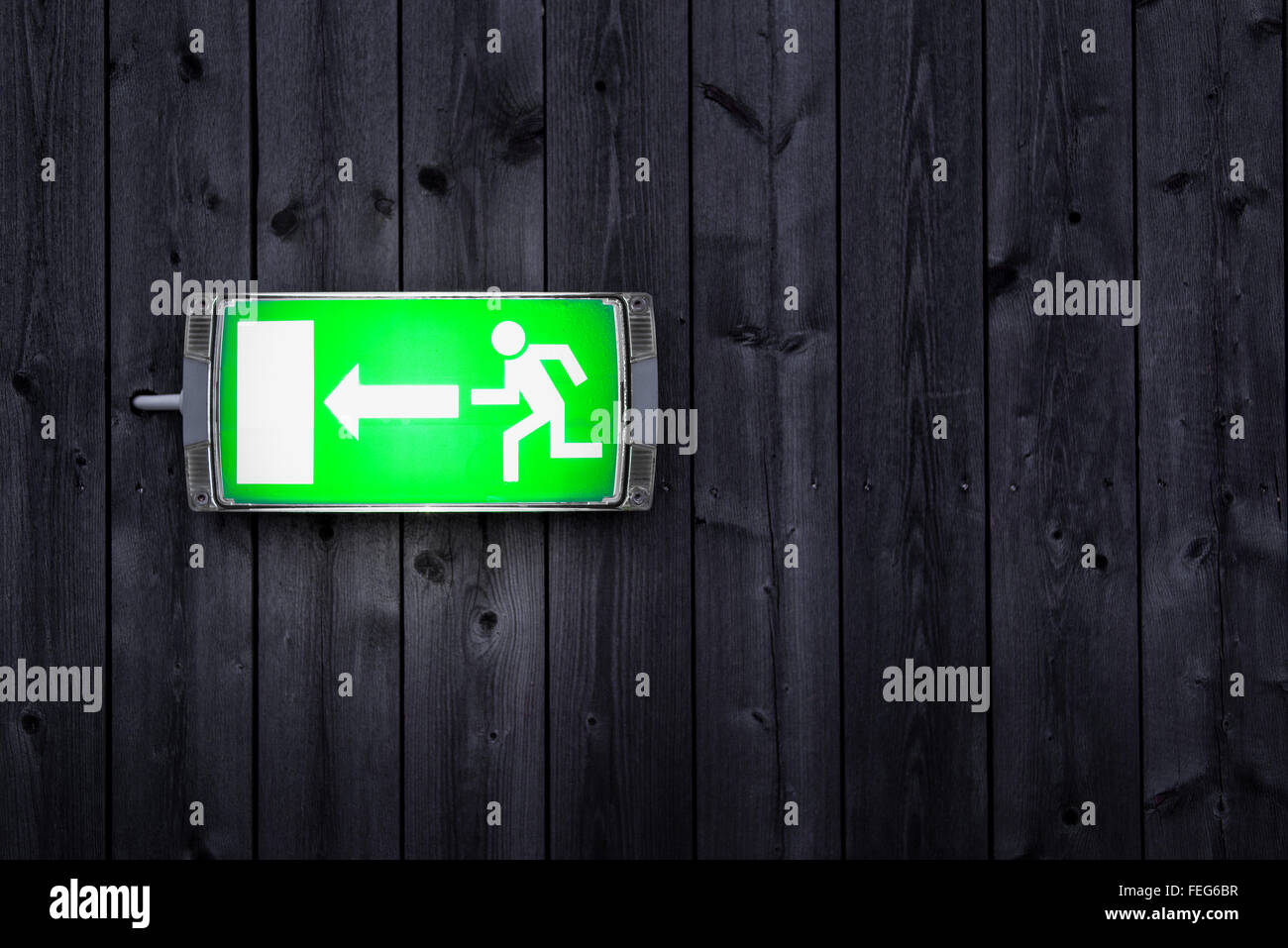 Uscita di emergenza segno su tavola in legno parete Foto Stock