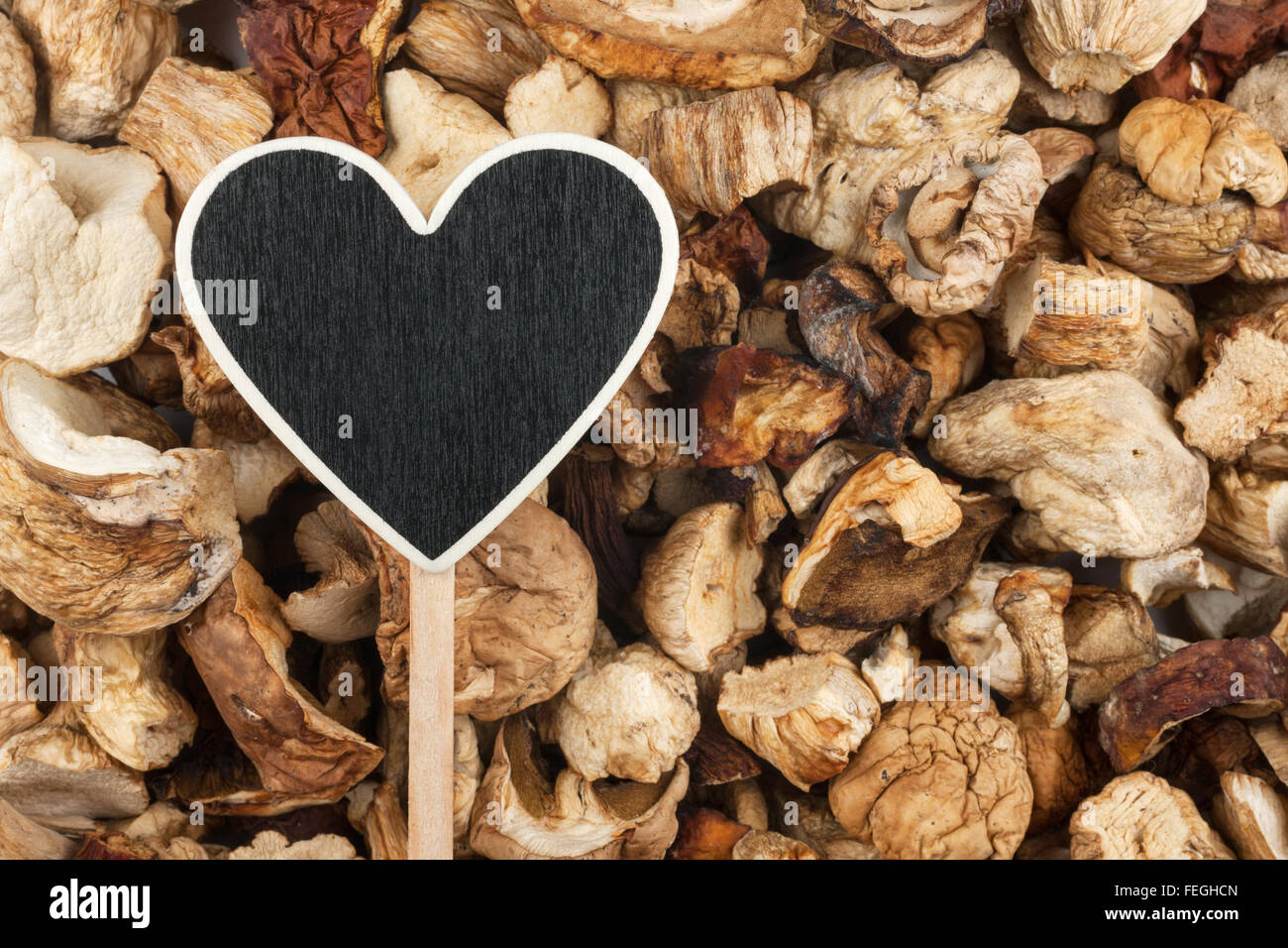 Il puntatore a forma di cuore si trova su funghi secchi, con spazio per il testo Foto Stock