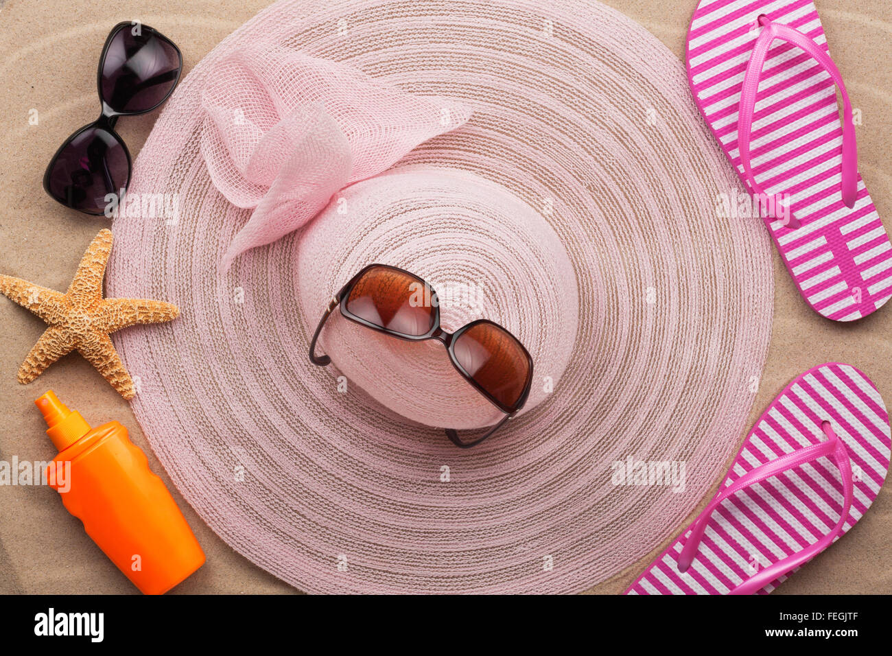 Vista superiore del cappello e il flip flop sulla spiaggia di sabbia, accessori sulla sabbia Foto Stock