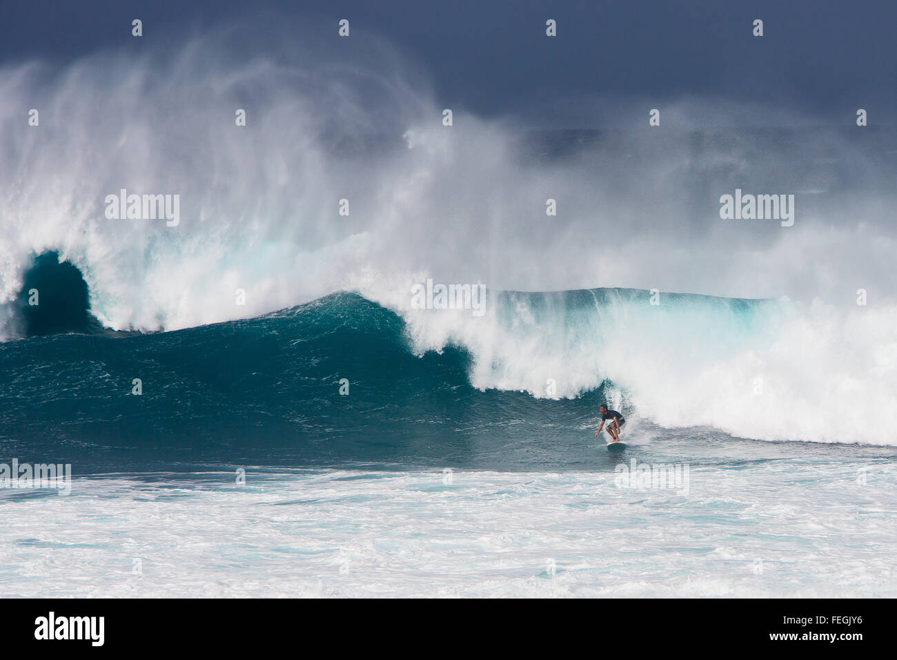 Un surfista Cavalca le onde nella parte anteriore del Hoʻokipa beach sull'isola di Maui, Hawaii (USA) Foto Stock