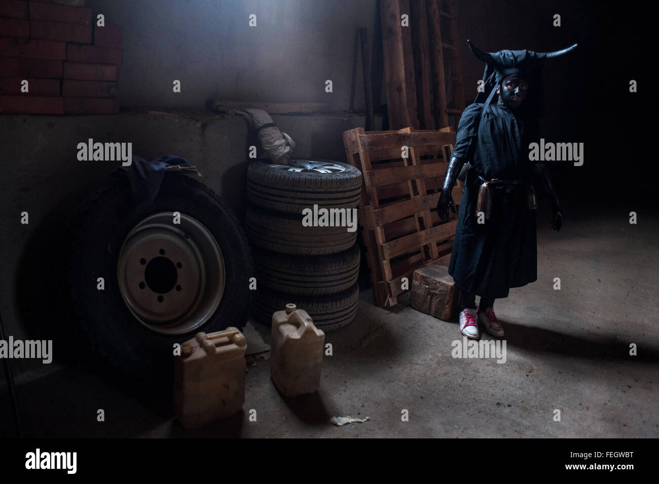 Un giovane uomo con il suo costume diavolo si sta preparando a partecipare al Carnevale di Luzon (Guadalajara) Foto Stock