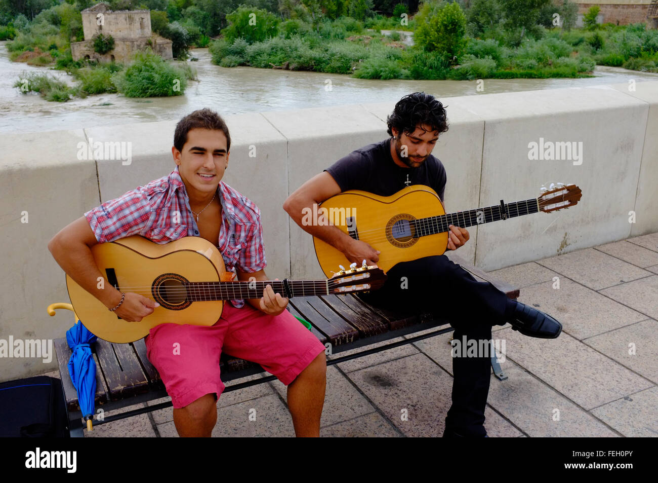Due chitarristi che si affaccendano sul ponte romano. Cordova. Spagna Foto Stock