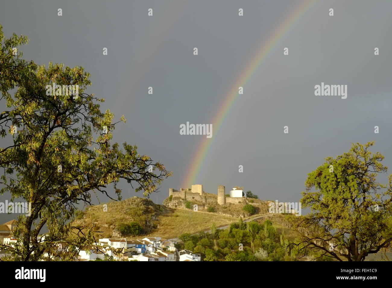 Arcobaleno sopra il castello moresco e la cappella. Carcabuey, Provincia di Cordova, Andalusia. Spagna Foto Stock