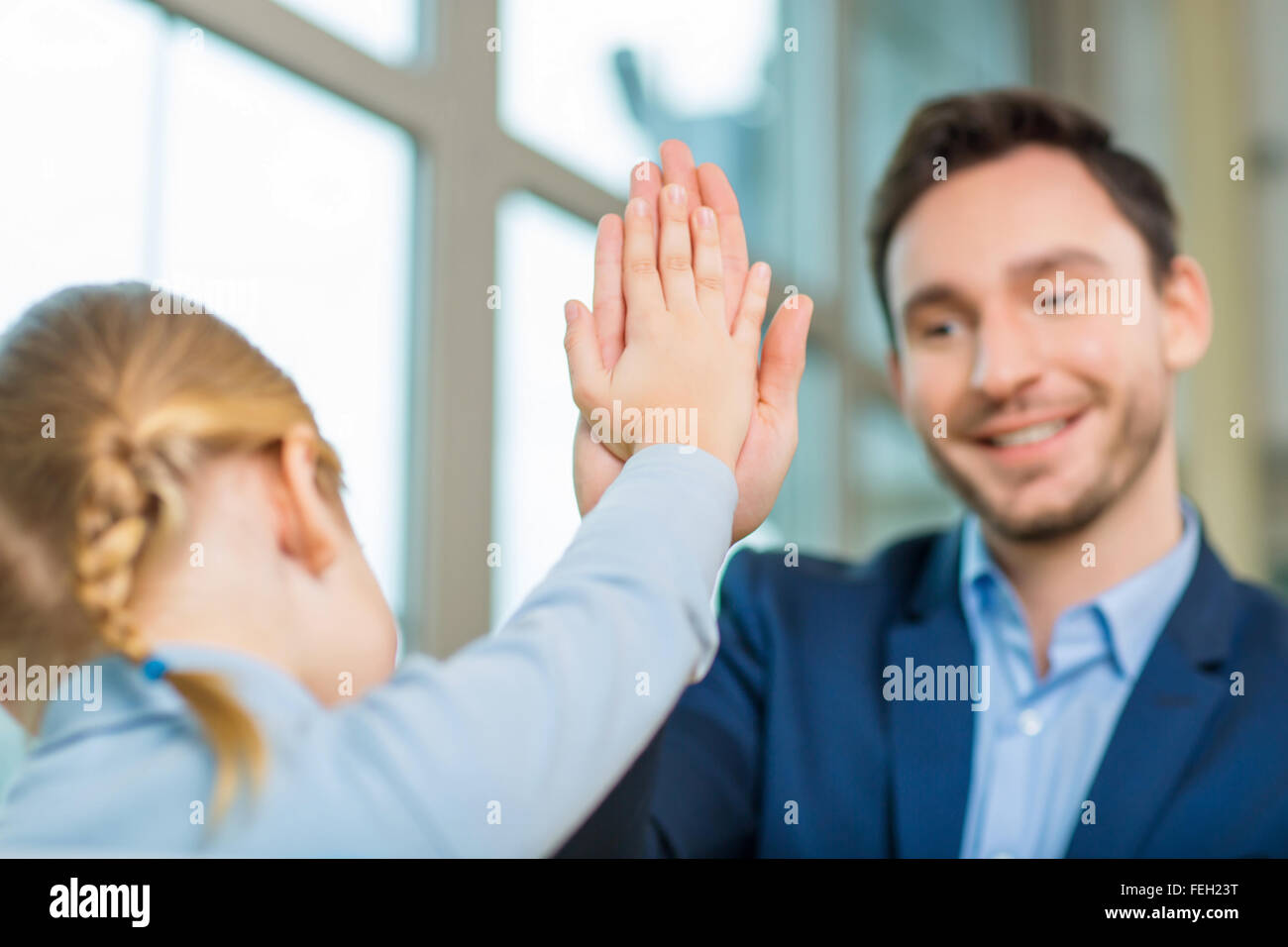 Padre e figlia rendendo un alto cinque gesto. Foto Stock