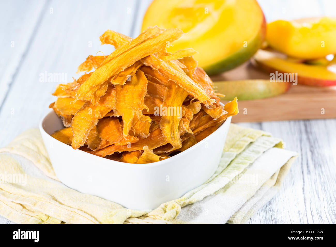 Una piccola ciotola con secchi fette di mango e frutta fresca Foto Stock