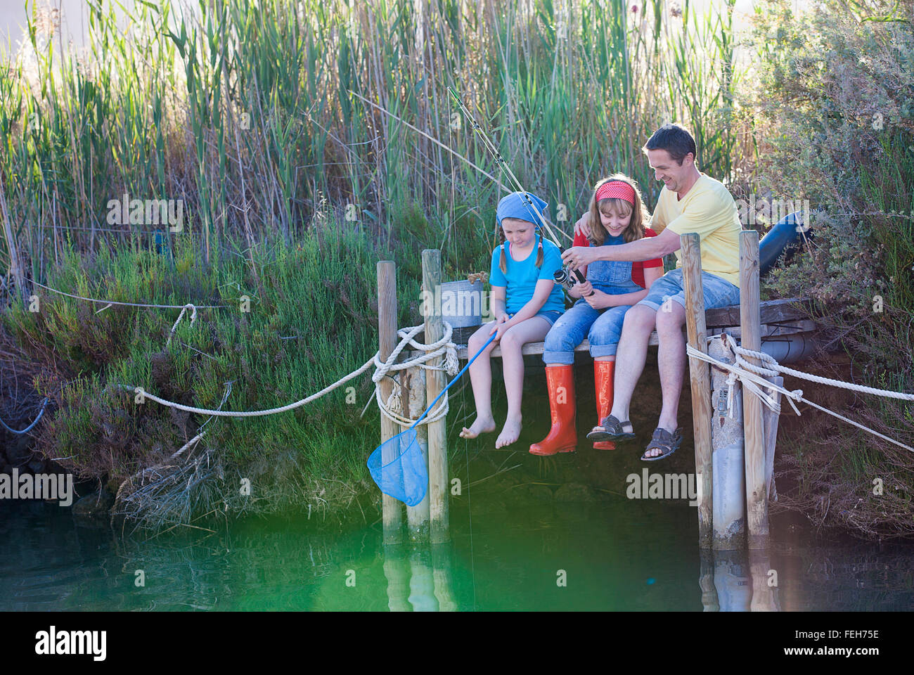 Il giorno della famiglia fuori la pesca di apprendimento da papà Foto Stock