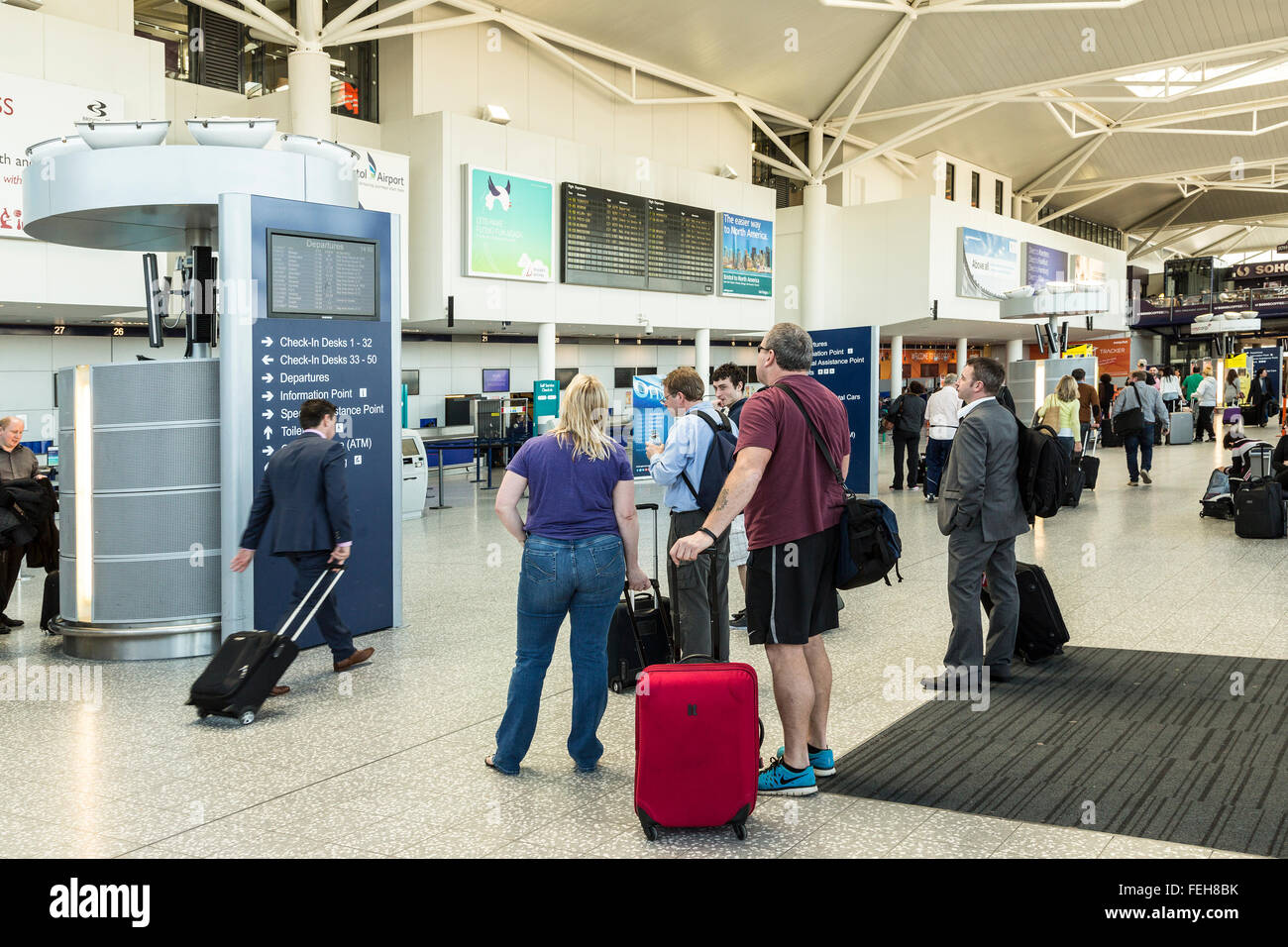 Passeggeri segno di lettura per i banchi check-in e le partenze presso l'aeroporto di Bristol, Inghilterra, Regno Unito Foto Stock