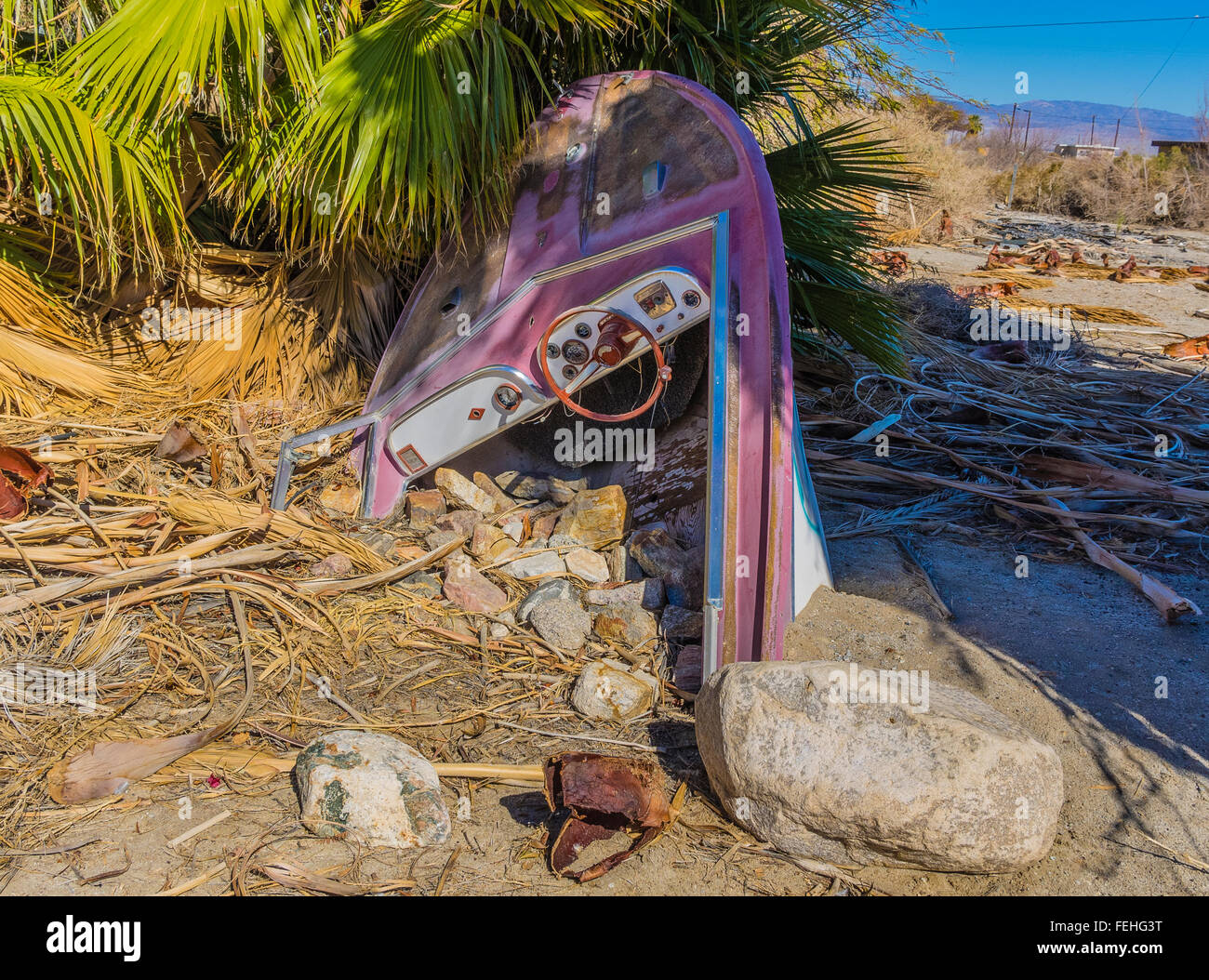 Vecchio sepolto speedboat presso la comunità di Salton Sea Beach con la metà di esso visibile e l altra metà sepolto. Foto Stock