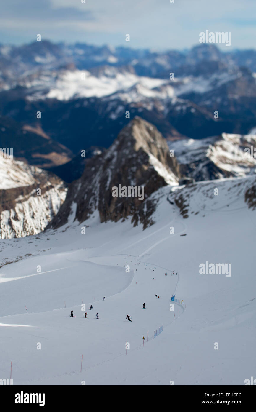 Tilt Shift vista di sciatori discendente dalla parte superiore della Marmolada. Dolomiti, Belluno, Italia. Foto Stock