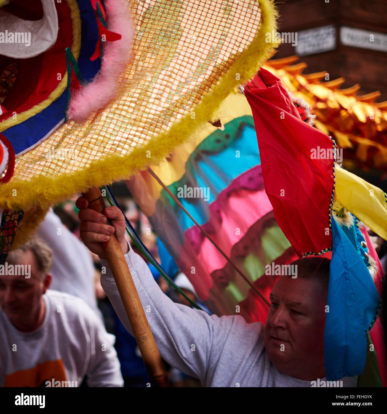 Capodanno cinese in Manchester. Un uomo che trattiene la testa del dragone aloft. Foto Stock