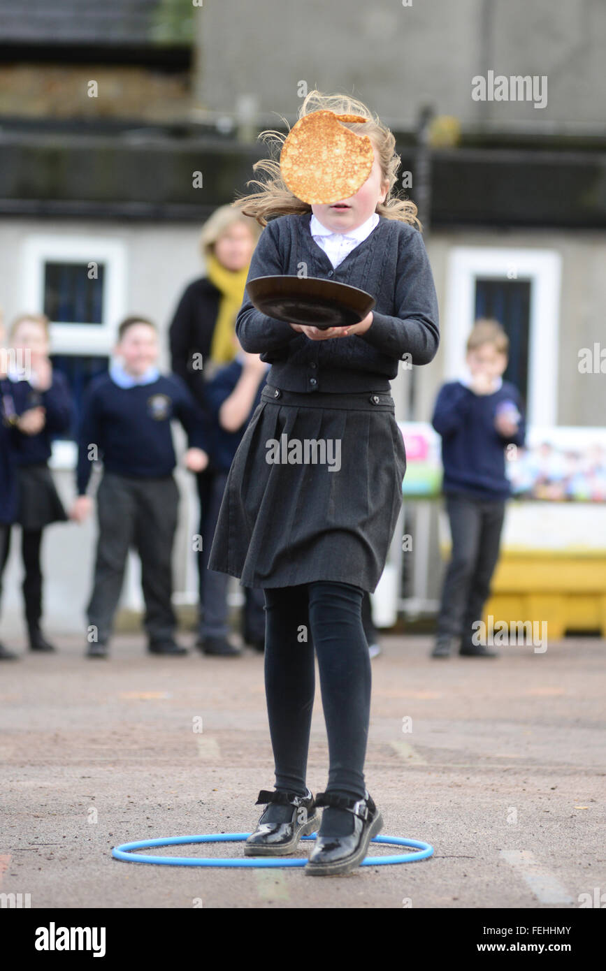 Una ragazza godendo di un pancake race. Foto Stock