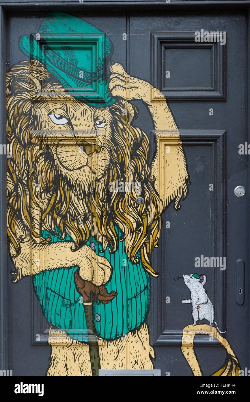 Aprile 2014 - Bristol, Regno Unito: un graffiti su una porta nera di un leone con un cappello verde e un mouse per la sua coda Foto Stock