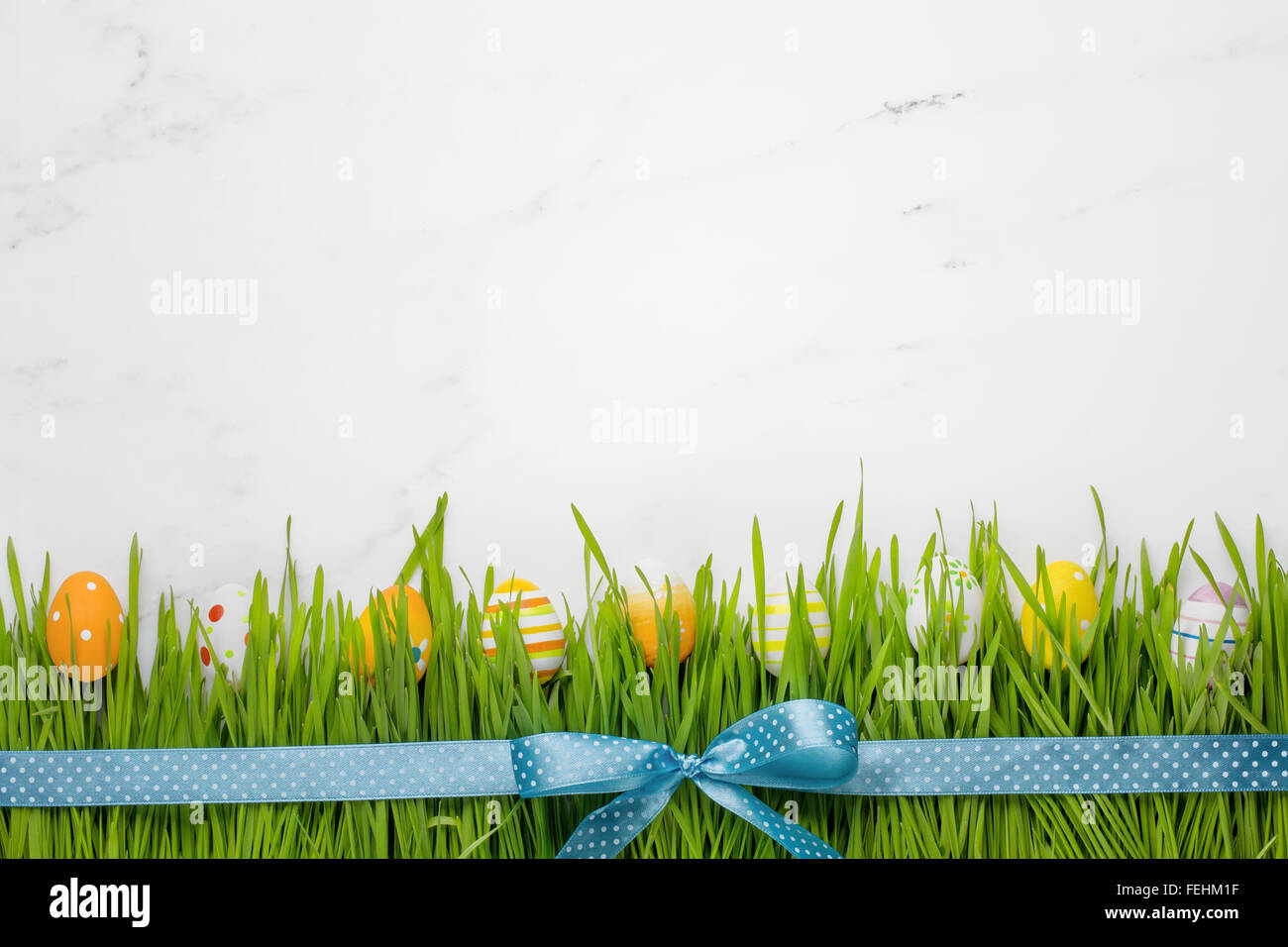 Uova di Pasqua in erba con prua a nastro Foto Stock