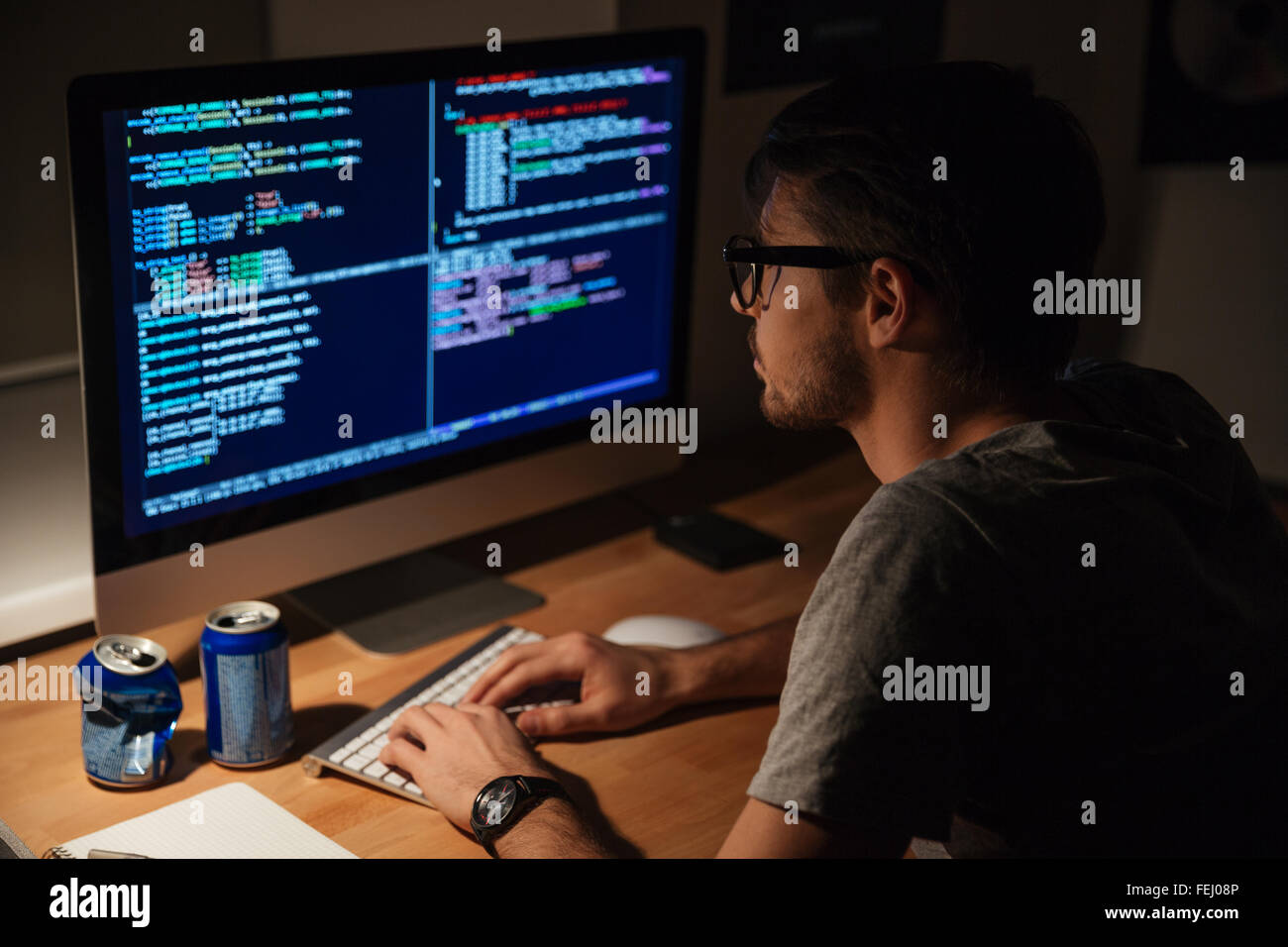 Considerato giovane programmatore codifica su computer in serata a casa Foto Stock