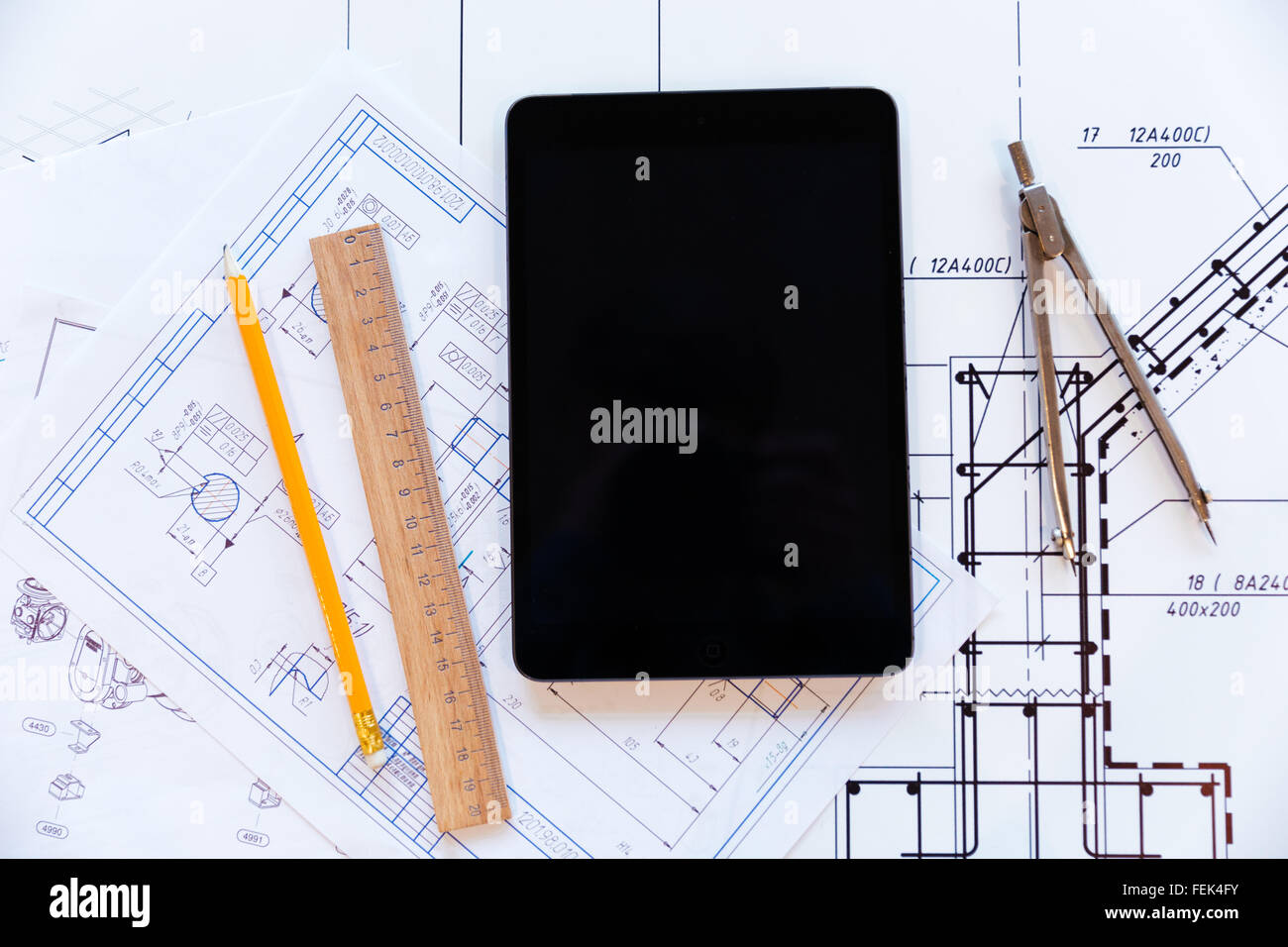 Closeup ritratto di un computer tablet e carta con blueprint Foto Stock