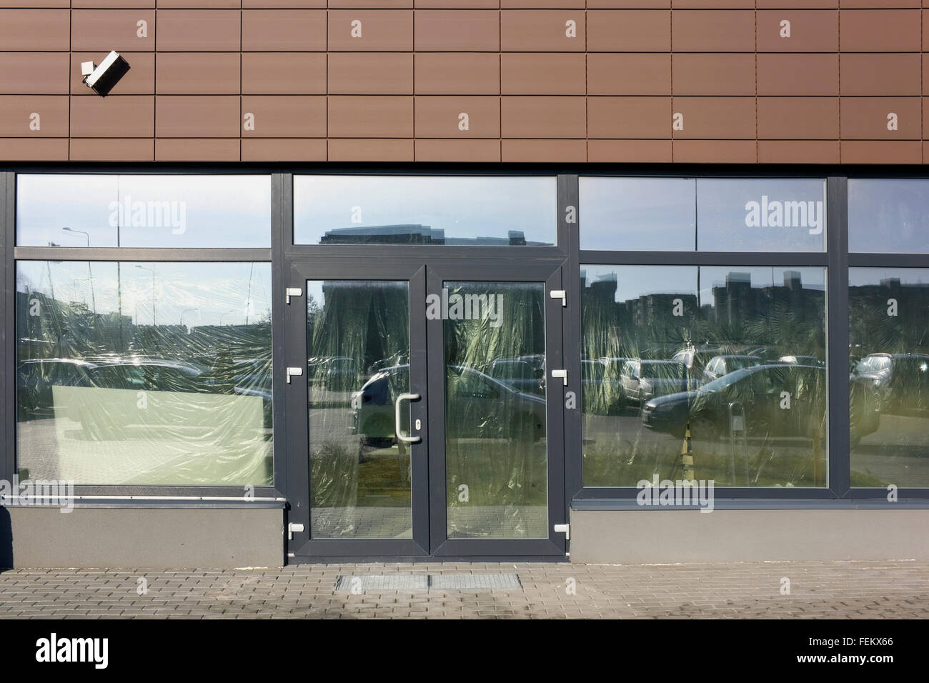 In ufficio con porte in vetro e finestre vi è un edificio. Le finestre sono chiuse da un foglio di plastica. L'ufficio si trova in residenti Foto Stock
