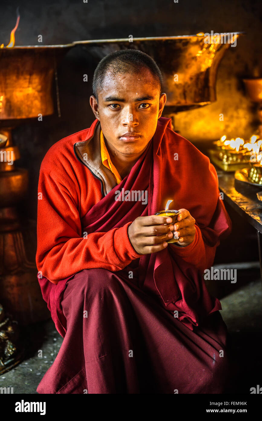 Monaco buddista di illuminazione a lume di candela all'interno di un tempio buddista di Kathmandu Foto Stock