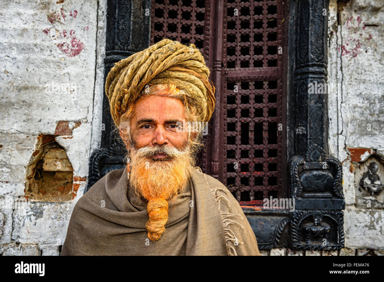 Sadhu errante baba (uomo santo) con i tradizionali lunghi capelli in un antico tempio di Pashupatinath Foto Stock