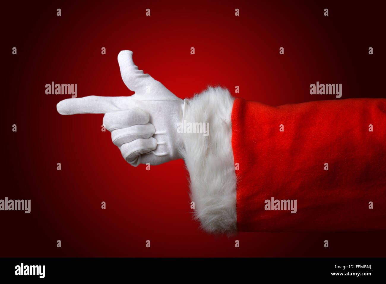 Babbo Natale, di puntamento della mano e del braccio solo su una luce al buio sfondo rosso Foto Stock
