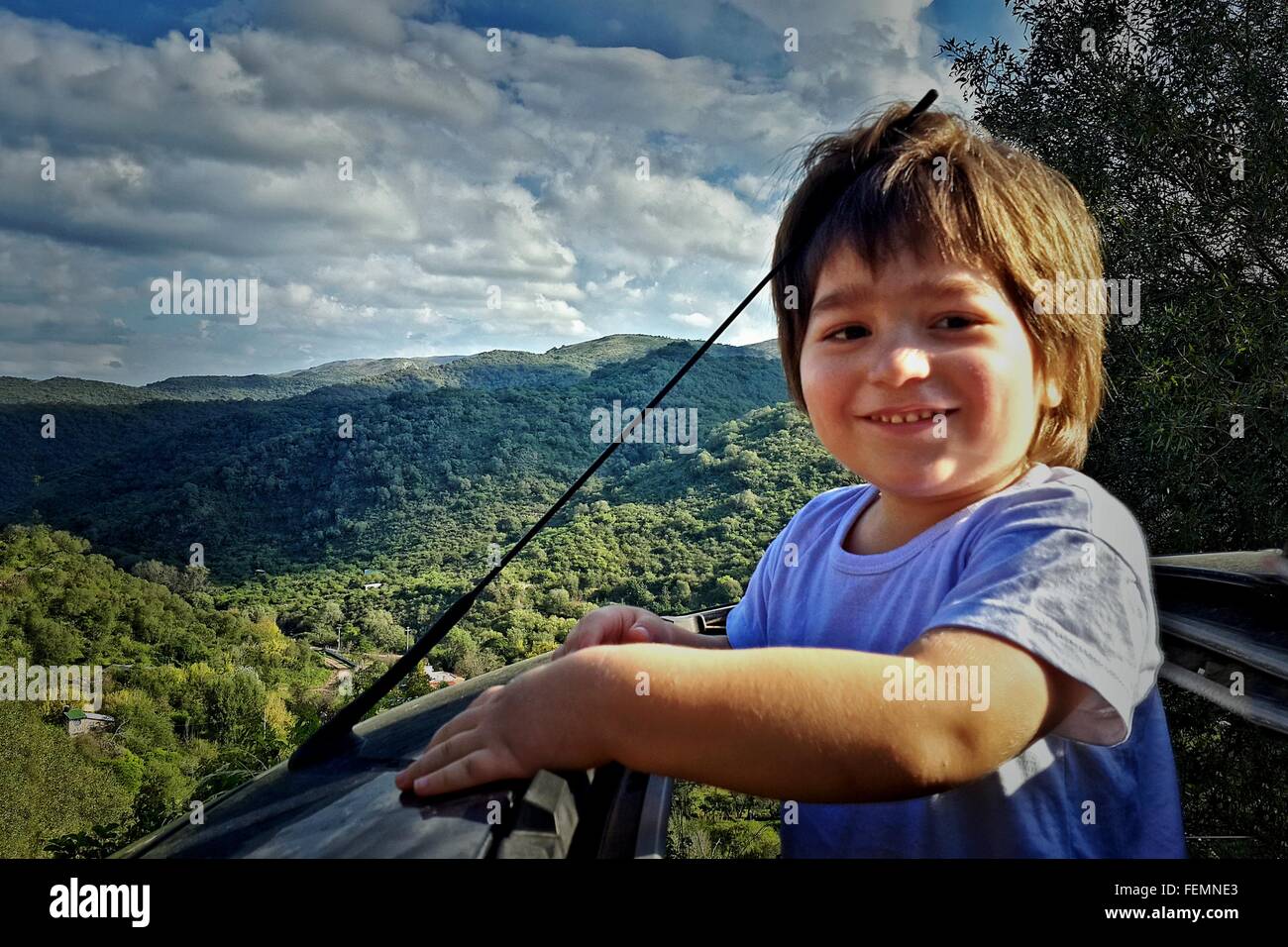 Felice ragazzo in piedi fuori auto del tettuccio apribile Foto Stock