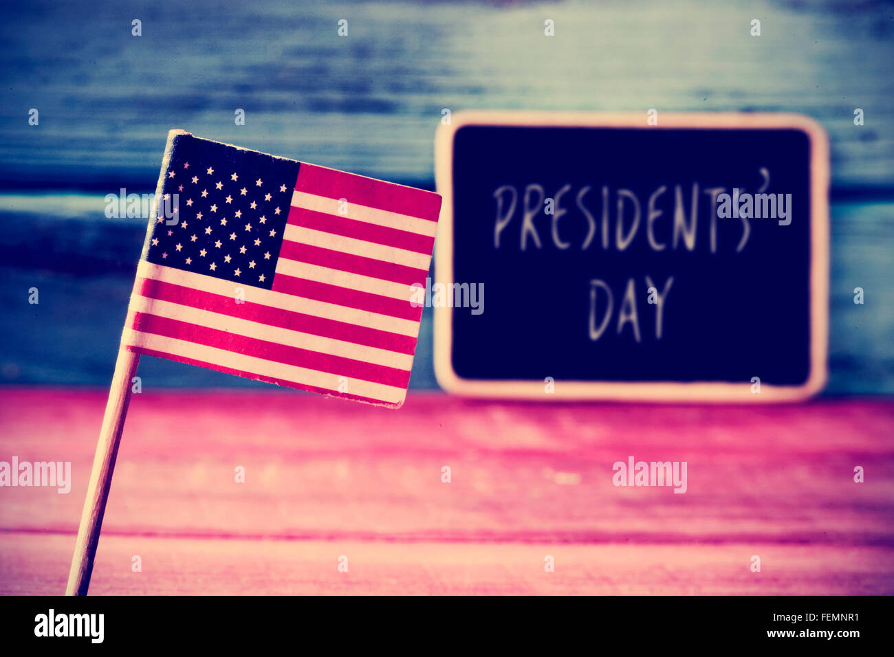 Bandiera degli Stati Uniti e il testo il testo presidenti giorno scritto in una lavagna, collocato su un blu e rosso legno rustico Foto Stock