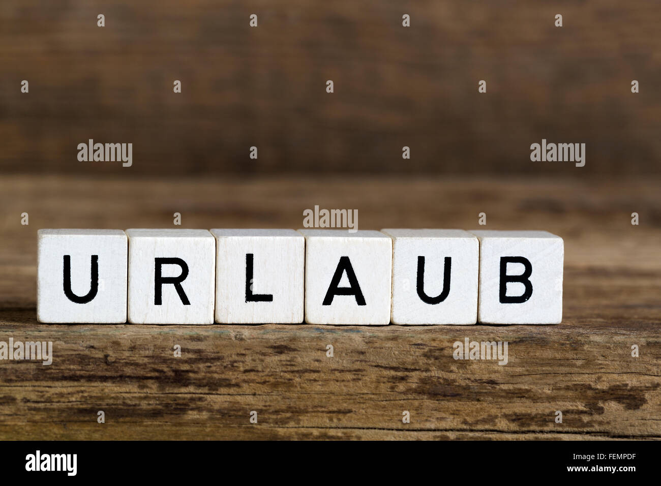 La parola tedesca vacanze scritto in cubi su sfondo di legno Foto Stock