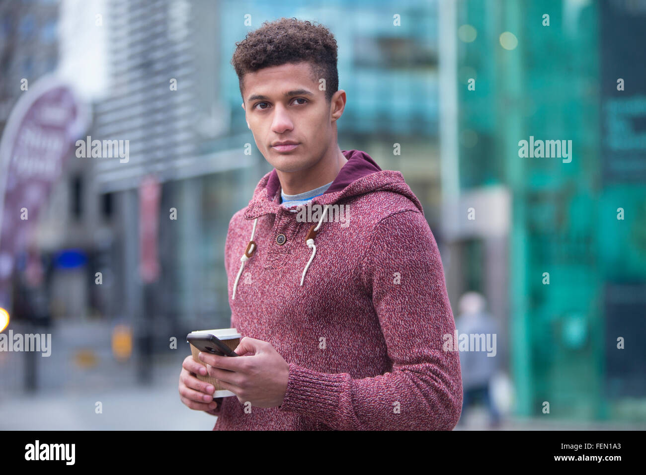 Giovani, mixed-gara uomo in città con uno smart phone Foto Stock
