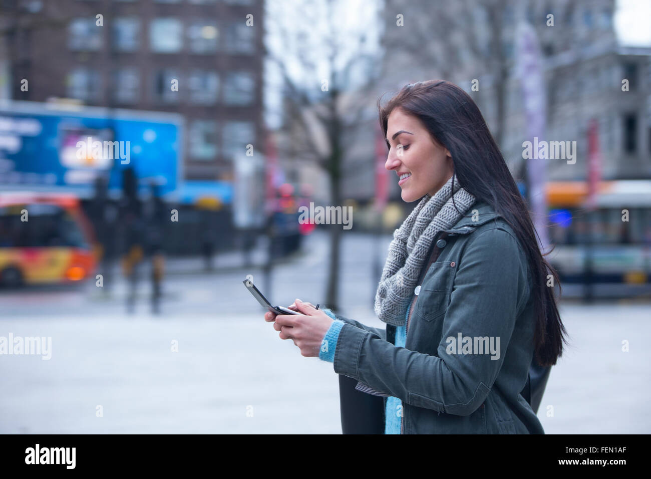 Giovane donna in città con uno smart phone. Foto Stock