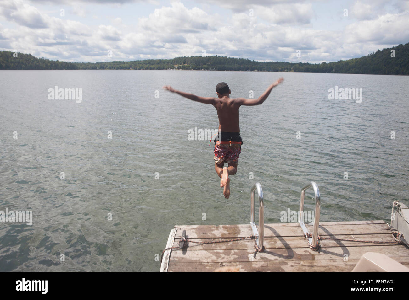 Ragazzo saltando in acqua Foto Stock