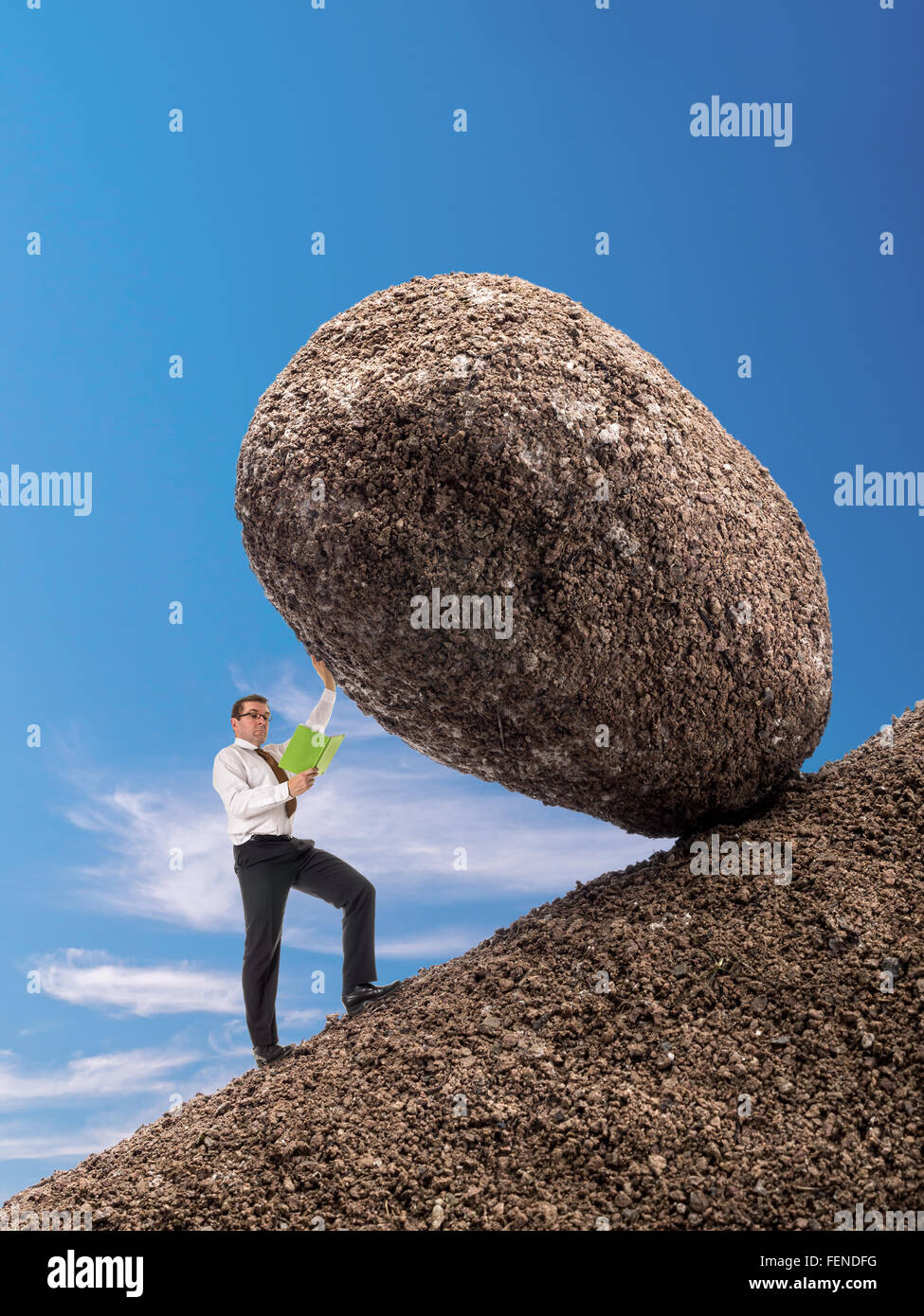 Imprenditore leggendo un libro in piedi sul pendio facilmente il bloccaggio boulder gigante con una mano di cadere verso il basso Foto Stock