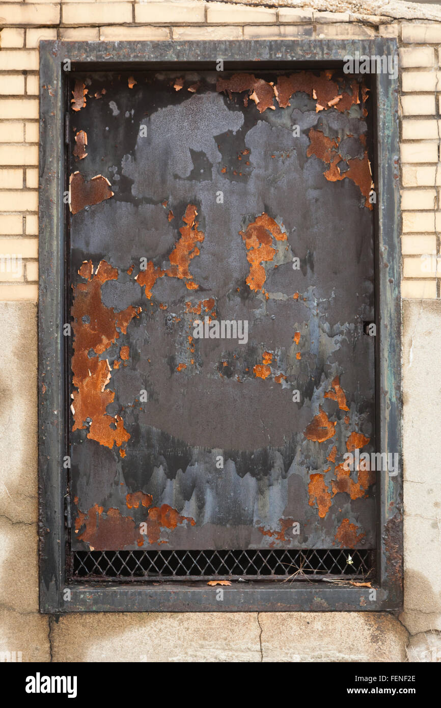 Un vecchio, ferro finestra coperto in uno stato di degrado con segni di ruggine Foto Stock