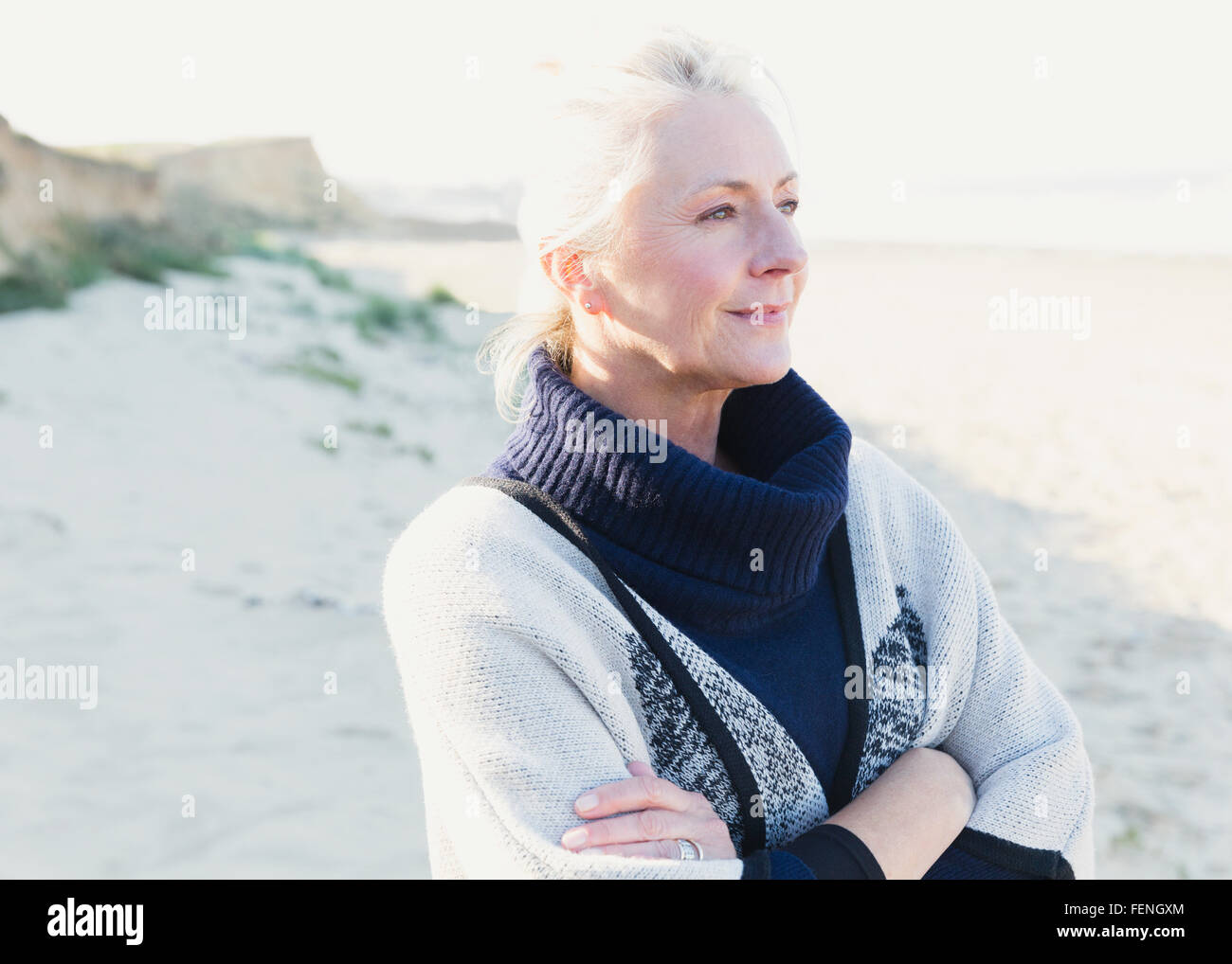 Malinconici senior donna che guarda lontano sulla spiaggia Foto Stock