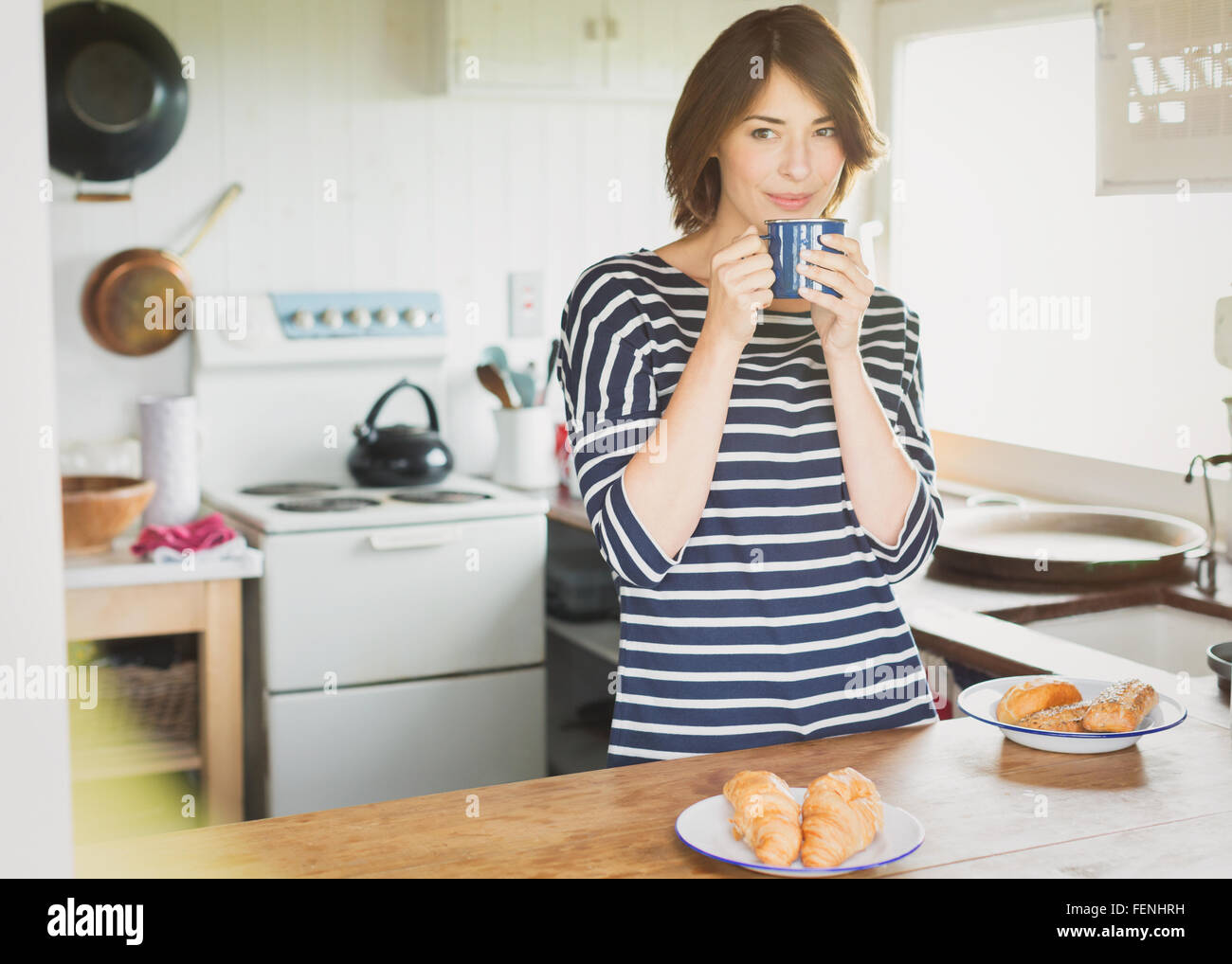 Brunette donna di bere il caffè in cucina Foto Stock