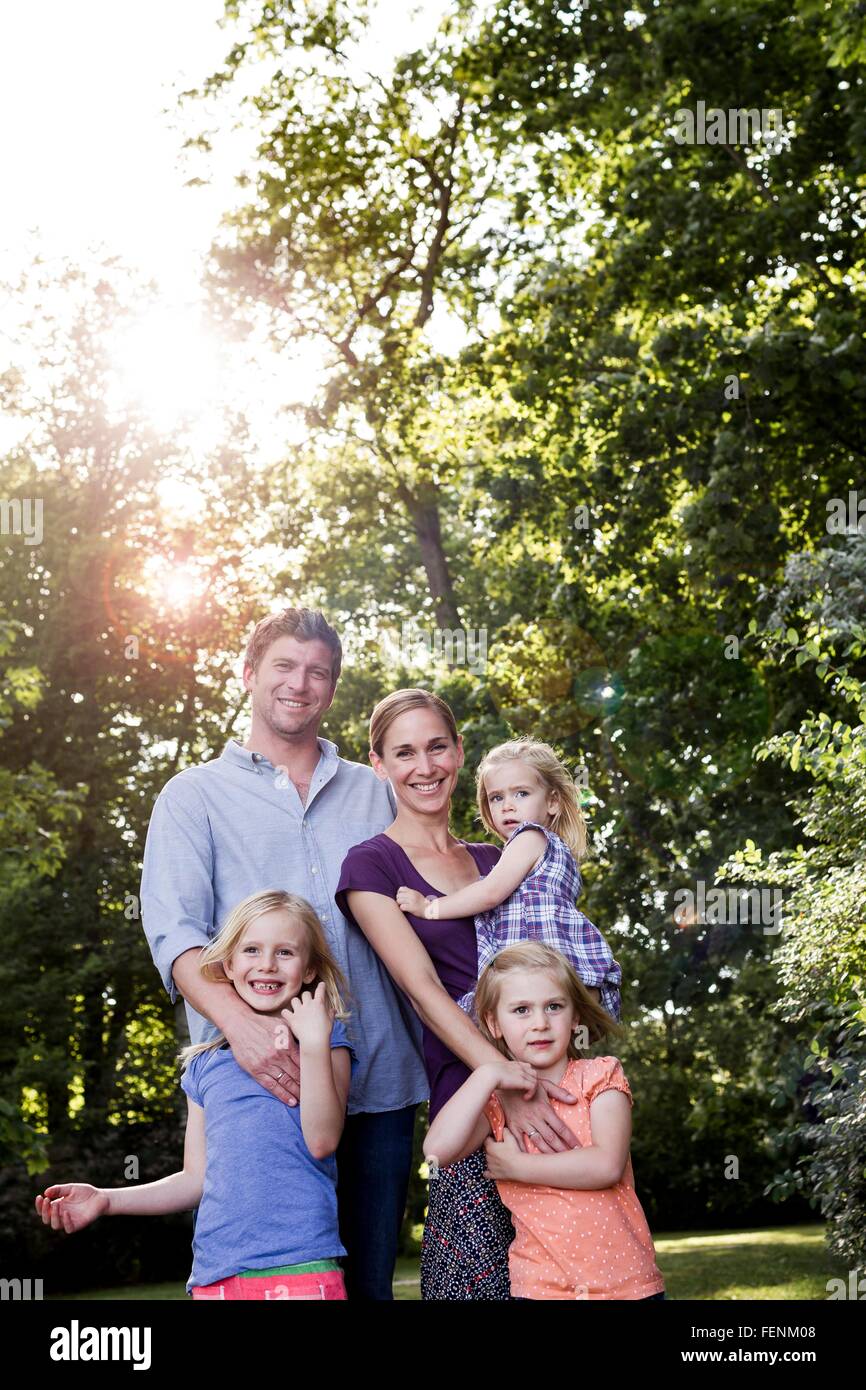 Ritratto di genitori e tre giovani figlie nel parco soleggiato Foto Stock