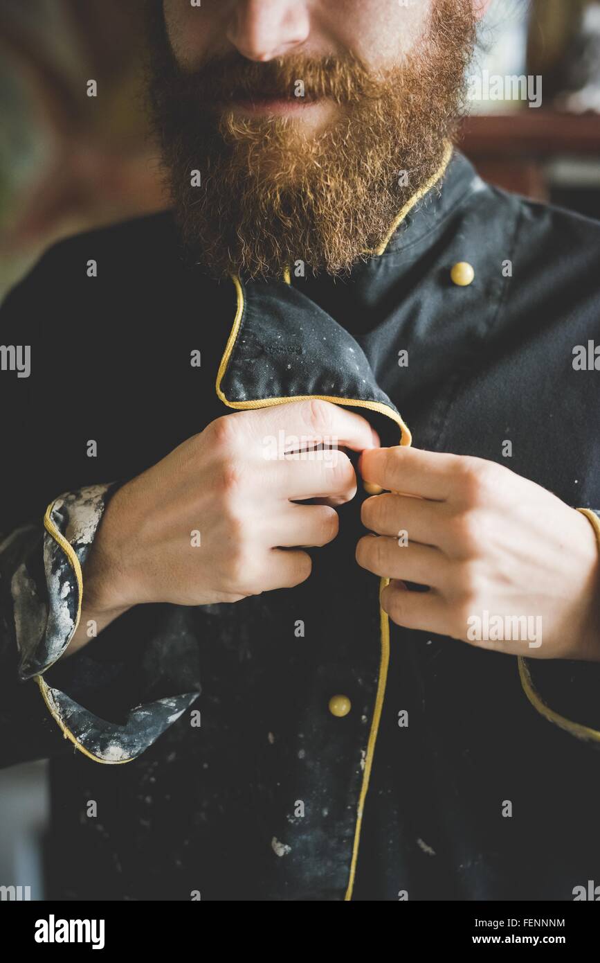 Vista ritagliata del barbuto metà uomo adulto abbottonatura fino ricoperta di argilla camicia Foto Stock
