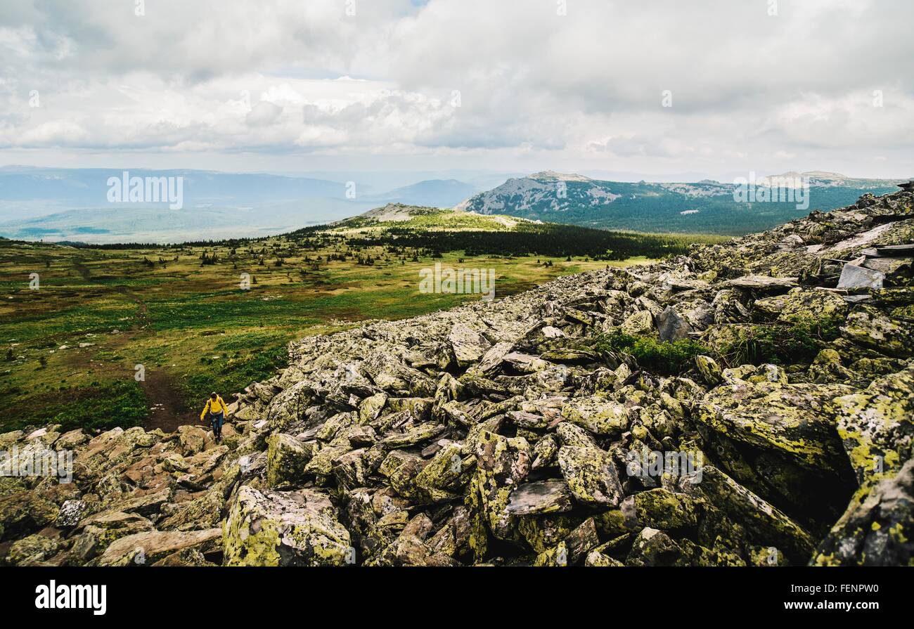 Vista posteriore di una donna sola escursioni nel paesaggio aspro, monti Urali, Russia Foto Stock