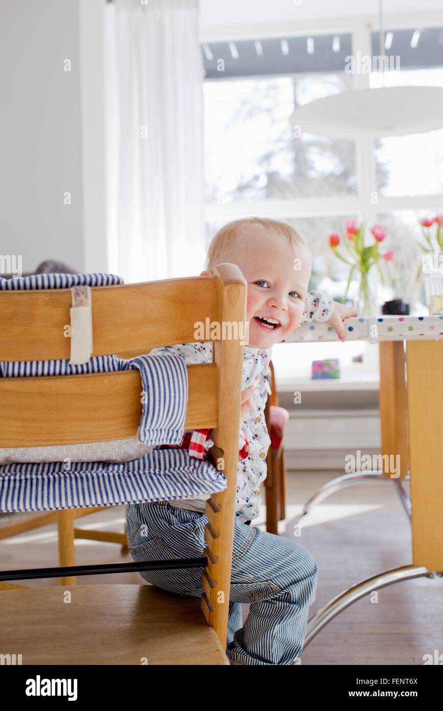 Ritratto di donna seduta toddler guardando sopra la sua spalla Foto Stock